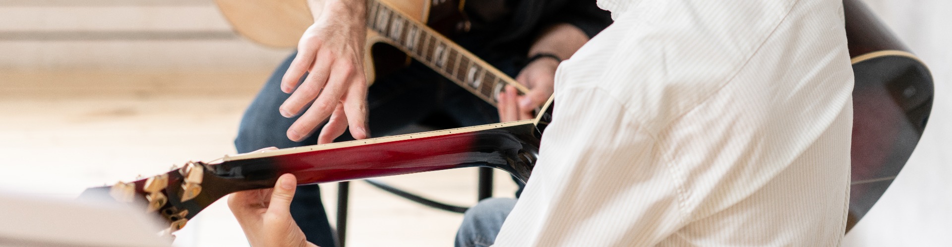 A personal tutor explains to his young student how to play studied chord correctly. Musical education at home