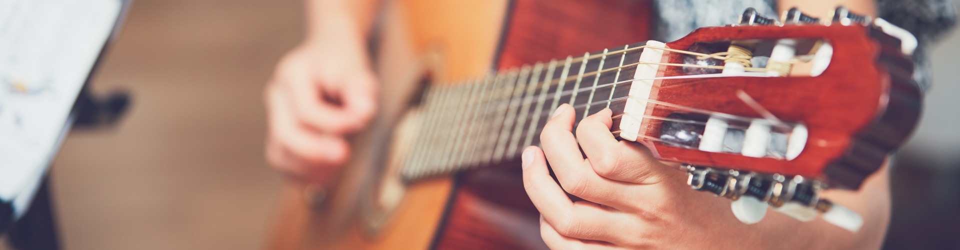 Girl learning to play to the guitar