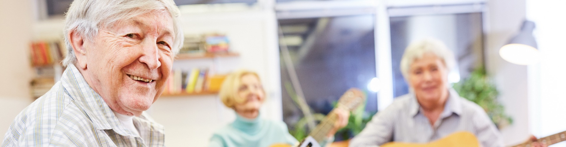 Senior man plays guitar in a guitar class