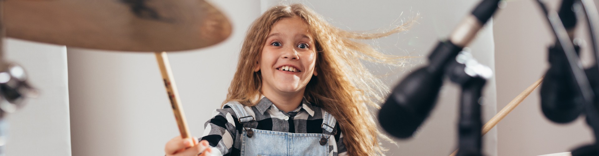 young girl playing drums in music studio